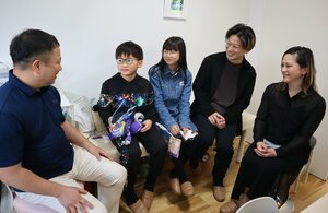 浅井さん（左端）に１０年前の治療への感謝を伝えた中嶋ヒロさん（左から２人目）ら家族＝大津市大江７丁目・あかい家のこどもクリニック