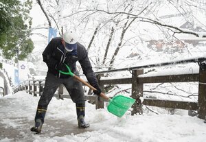 雪かきをする人（１日午前９時７分、福知山市内記・福知山城）
