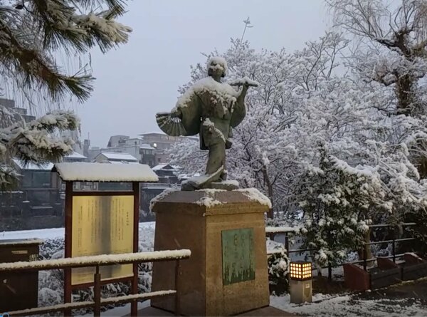 雪化粧した「出雲の阿国」像（21日午前、京都市東山区）