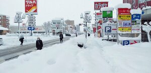 歩道に積もった雪をよけ、車道を歩く市民ら（２７日午前８時ごろ、彦根市長曾根南町）
