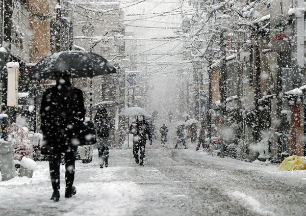 <div class="caption">雪が降り積もる三条通を歩いて通勤する人たち（２１日午前８時５６分、京都市中京区・三条通西洞院西入ル）</div>
