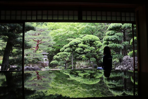 新緑の庭園が広がる旧邸御室の大広間。手前のテーブルは鏡面のように景色を映し出す（京都市右京区御室）