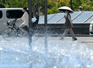 強い日差しを日傘で避け、交差点を通り抜ける人たち（２４日午後１時５１分、京都市中京区・河原町御池交差点）