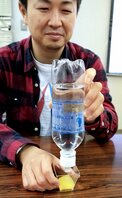規定量の水を入れてカメルカを装着したペットボトルを当て、食品の硬さを確かめる高田さん（京都市伏見区）
