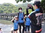 サンガとの試合前に嵐山を訪れ、渡月橋での記念撮影を楽しむ川崎フロンターレのサポーター（京都市右京区）
