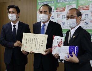 自社製マスクを寄付し、感謝状を手にするＭＴＧの大田会長（中央）と松下社長（左）＝京都市中京区・市役所