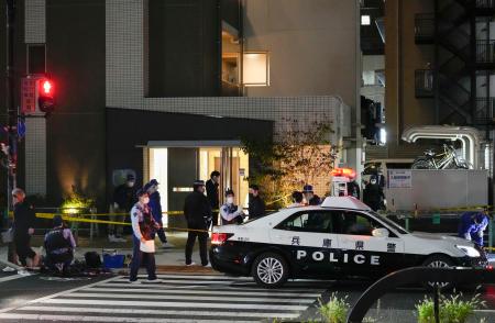 女性が刺された現場付近で警戒する警察官＝１５日午後１０時３分、兵庫県尼崎市