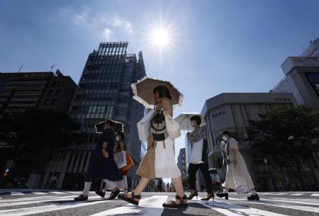 強い日差しの中、日傘を差して歩く人たち＝１日、名古屋市