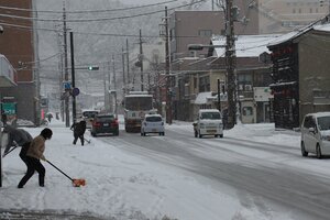 雪が降り積もった市街地で、早朝より雪かきに追われる住民ら（舞鶴市浜町、１７日午前８時１４分）