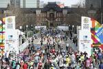 東京マラソンでゴールする市民ランナーら。奥は東京駅＝３月、東京都千代田区（代表撮影）