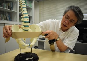 シートベルトが衝撃を緩和する仕組みについて骨盤の模型を使いながら説明する名古屋大の水野教授（５日、名古屋市内）