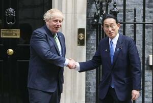 　５月、首相官邸前で岸田首相（右）を出迎え、握手を交わすジョンソン英首相＝ロンドン（共同）