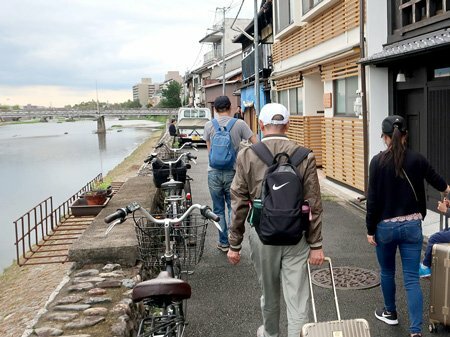 予約した簡易宿所に向かって鴨川沿いを歩く中国人の家族連れ（京都市内）