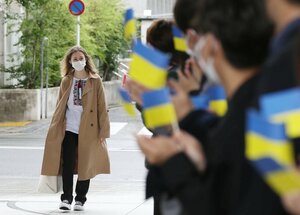 龍谷大を訪れ、ウクライナ国旗を手にした学生からの歓迎を受けるオレクシューク・ロクソラーナさん（13日午前11時５５分、京都市伏見区）