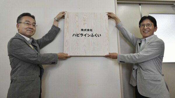 新社名の看板を設置する福井県の杉本達治知事（左）ら＝４日午前、福井市
