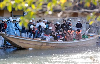 救急隊らが待つ中、到着地の嵐山で船から降りる乗客たち（２８日午後３時３２分、京都市）