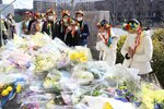 ウクライナへの軍事侵攻を受けて設置された献花台に花を手向けた後、手を合わせる寺田バレエ・アートスクールの生徒たち（京都市中京区・市役所前広場）
