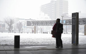 福知山駅のロータリーで雪の様子をうかがう人（１日午前８時４２分、福知山市駅前町・福知山駅）