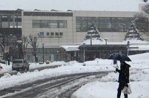 断続的に雪が降り続くＪＲ東舞鶴駅前。歩行者や車が路面を気にしながら通っていた（３１日午後２時７分、舞鶴市浜）