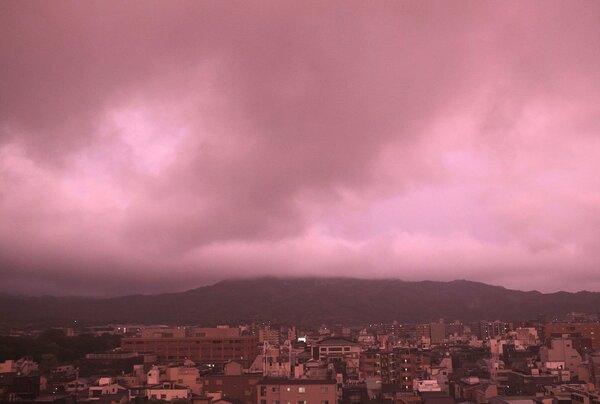 空が赤紫色に染まる夕暮れの京都市中心部（２９日午後６時４３分、京都市中京区・京都新聞本社から東を望む）