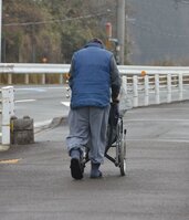 重たい水を車いすに乗せて、片道３０分の帰路に就く高齢者（2月27日撮影、南丹市日吉町）