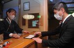 ワクチン・検査パッケージに必要な書類を提出する利用者（右）＝２１日、京都市右京区