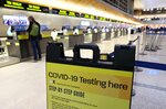 新型コロナウイルスの検査場所を示す案内板が置かれた米ロサンゼルスの空港＝１日（ゲッティ＝共同）