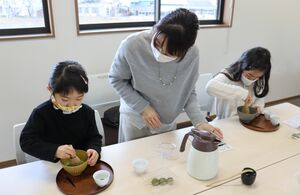 抹茶アート体験を楽しむ家族ら（和束町観光案内所）